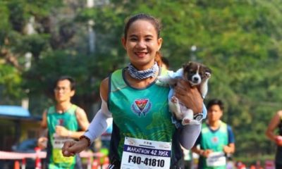 Mulher com cachorro no colo em corrida