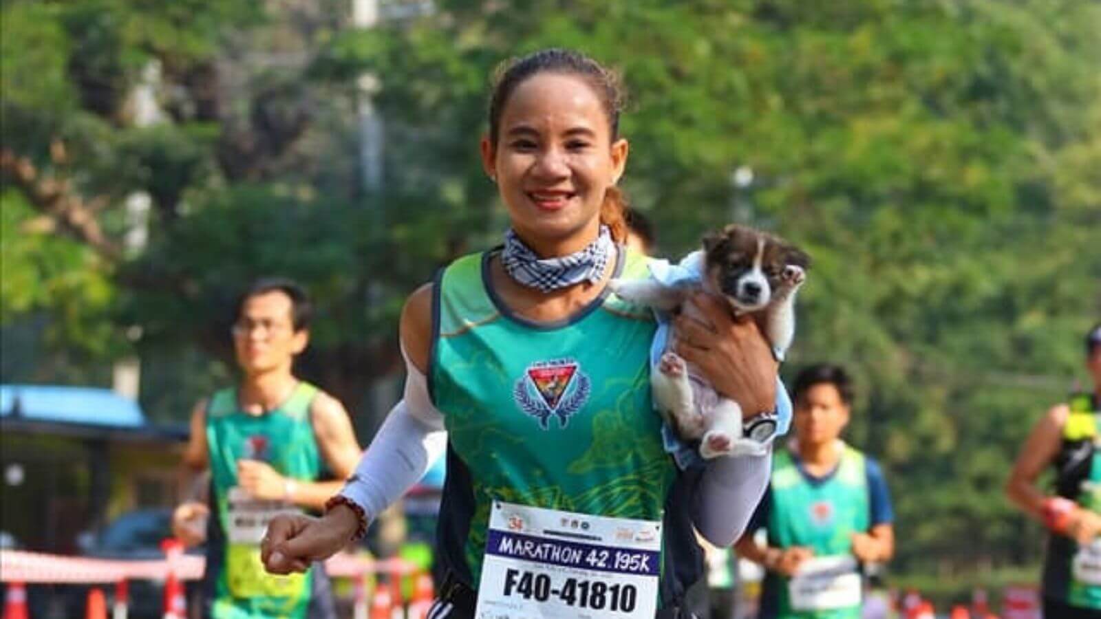 Mulher com cachorro no colo em corrida